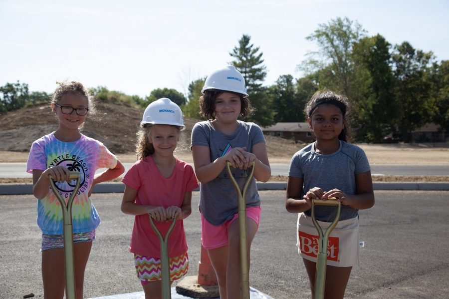 girls leaning on shovels